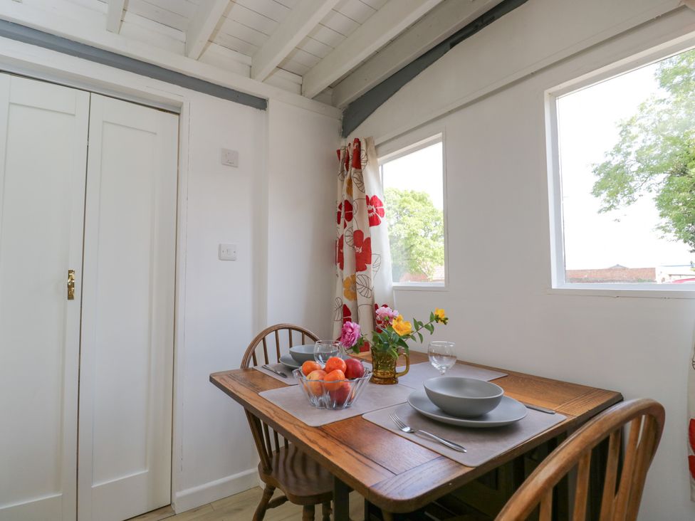 A dining room with a table set for meals at Coach House in Swindon