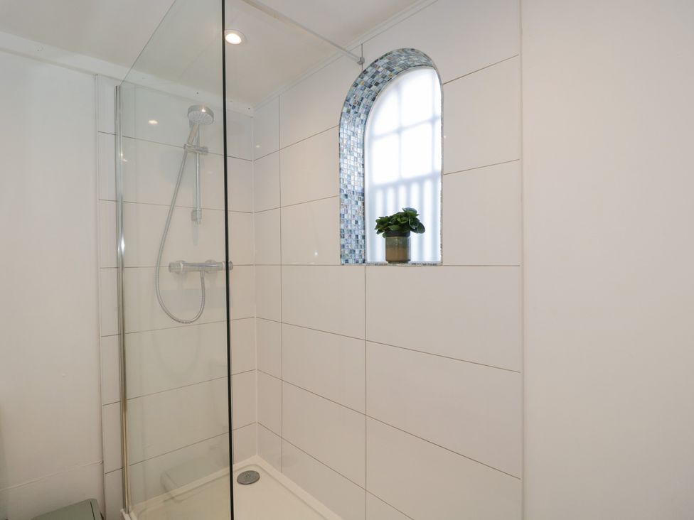A shower with glass enclosure in a bathroom at Coach House Swindon