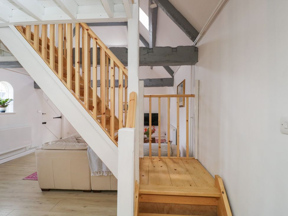 A living room with a staircase and sofa at Coach House in Swindon