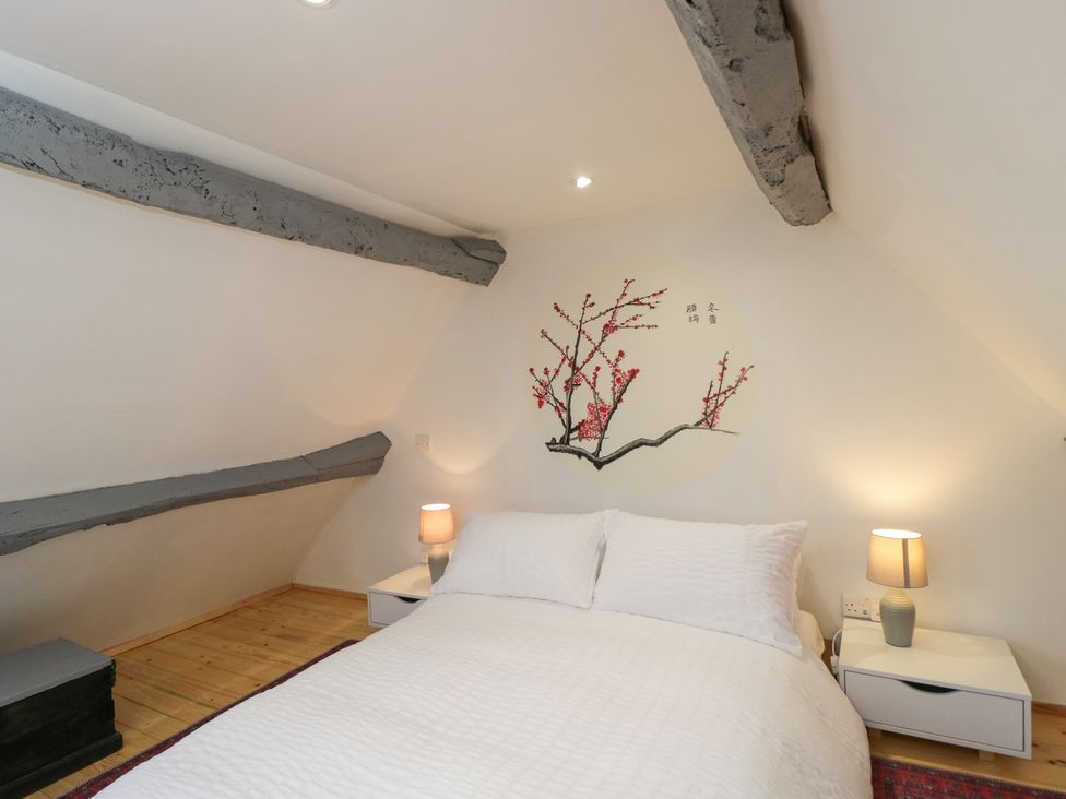 A bedroom with a bed and wall art at Coach House in Swindon