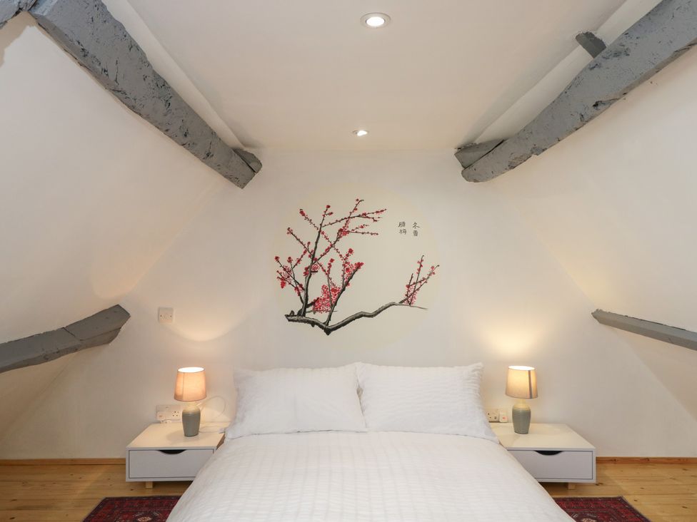 A bedroom with a bed and side tables at Coach House in Swindon