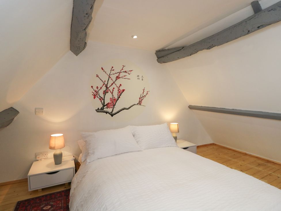 A bedroom with a bed and bedside tables at Coach House in Swindon