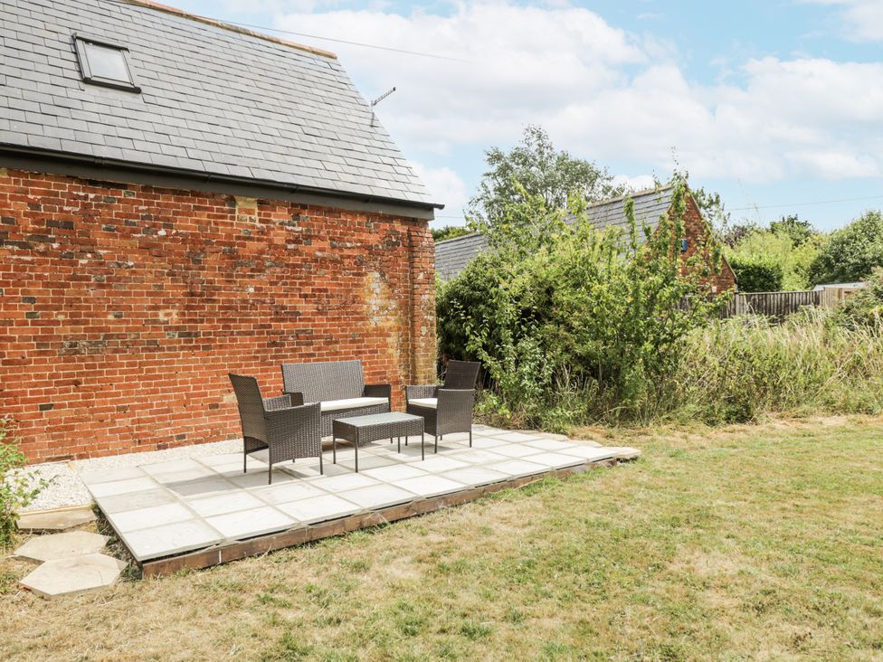 An outdoor patio with furniture at Coach House in Royal Wootton Bassett