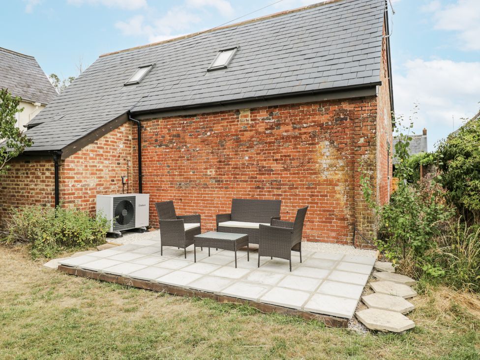 A garden with patio furniture at Coach House in Royal Wootton Bassett