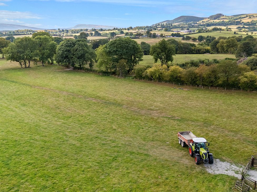 An outdoor scene with a tractor and trailer in a field at The Fox Den Nantmel near Rhayader