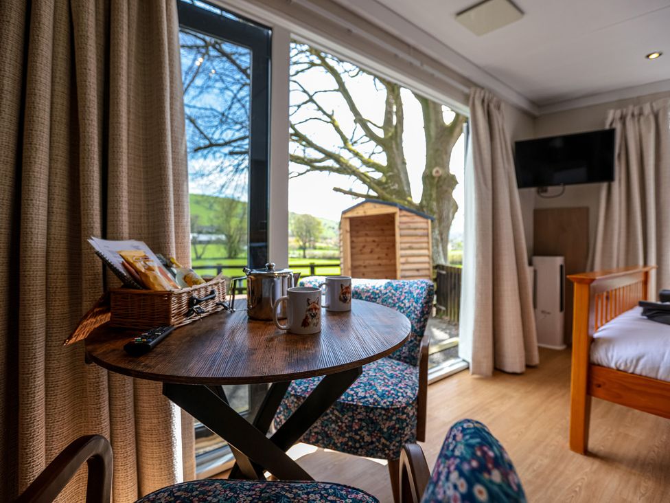 A living room with a table and chairs at The Fox Den in Nantmel near Rhayader