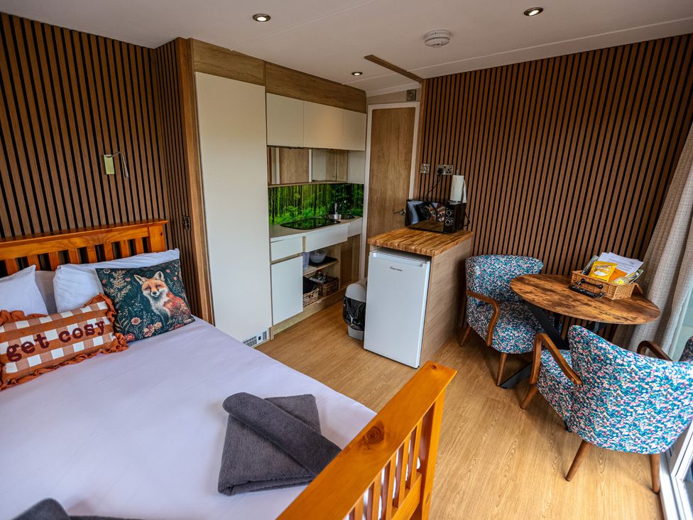 A bedroom with a bed and kitchenette at The Fox Den Nantmel near Rhayader