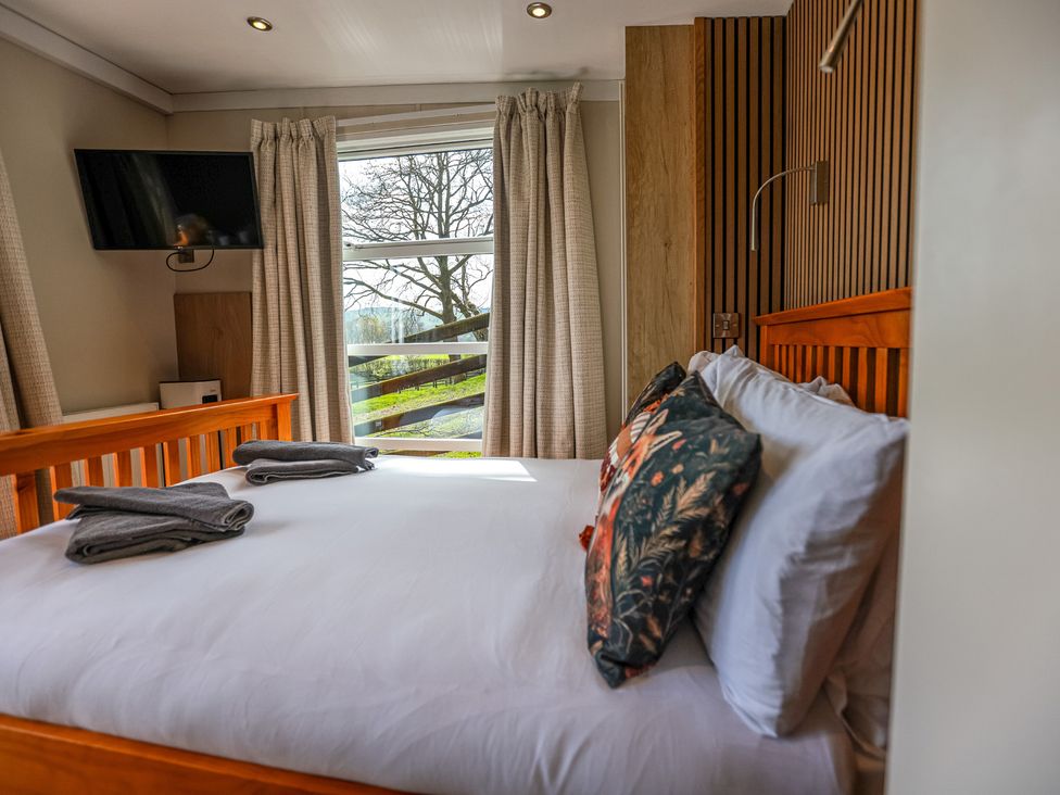 A bedroom with a bed and television at The Fox Den near Rhayader
