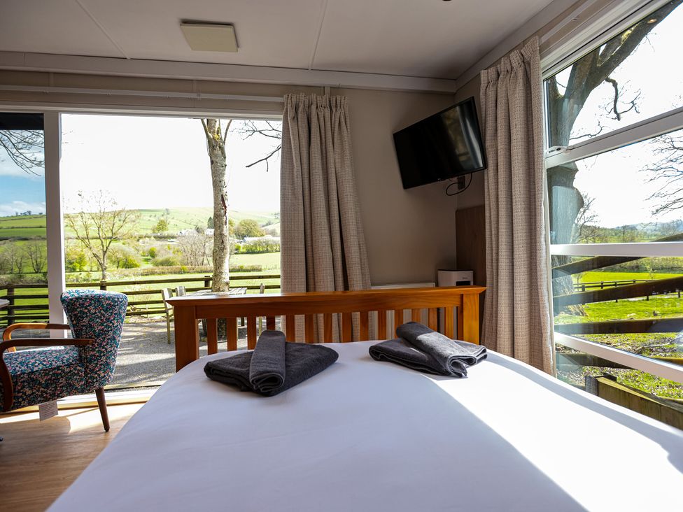 A bedroom with a bed and towels at The Fox Den in Nantmel near Rhayader