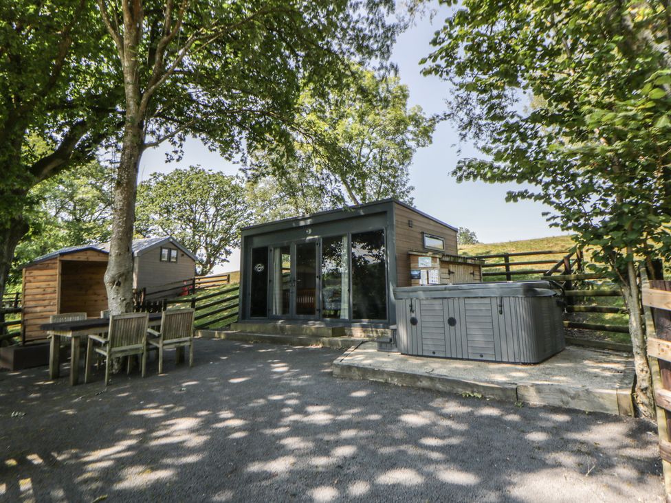 An outdoor area with a hot tub and seating at The Fox Den in Nantmel near Rhayader