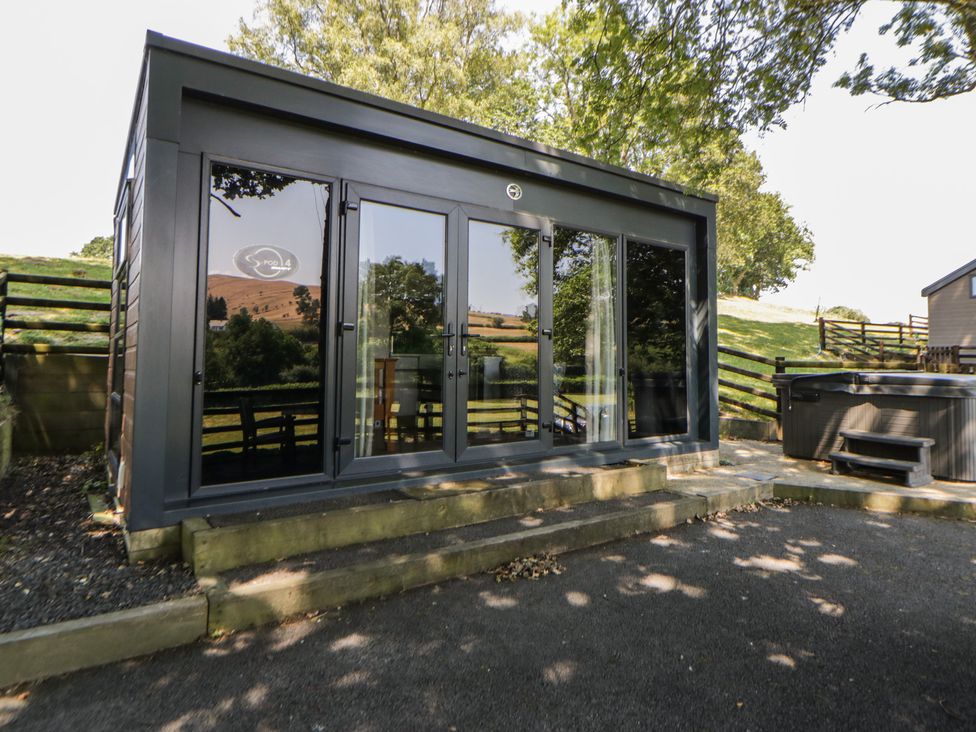 A building with large doors and a hot tub at The Fox Den Nantmel near Rhayader