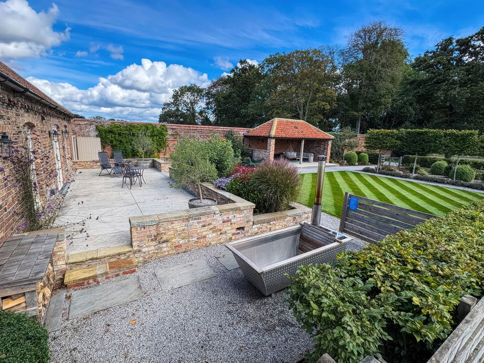 A garden with a patio and furniture at Flittermouse Barn Hornsea