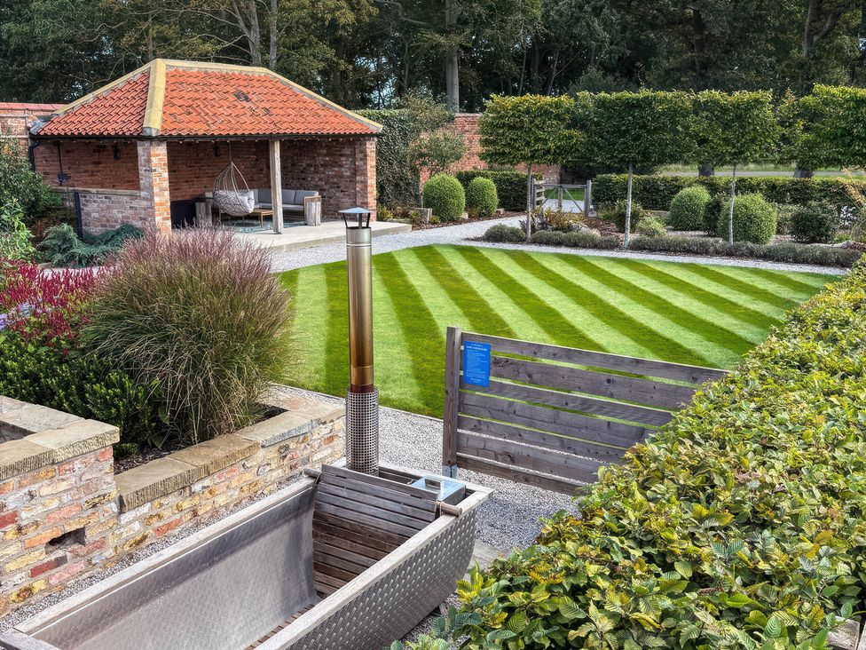 A garden with a gazebo and lawn at Flittermouse Barn Hornsea