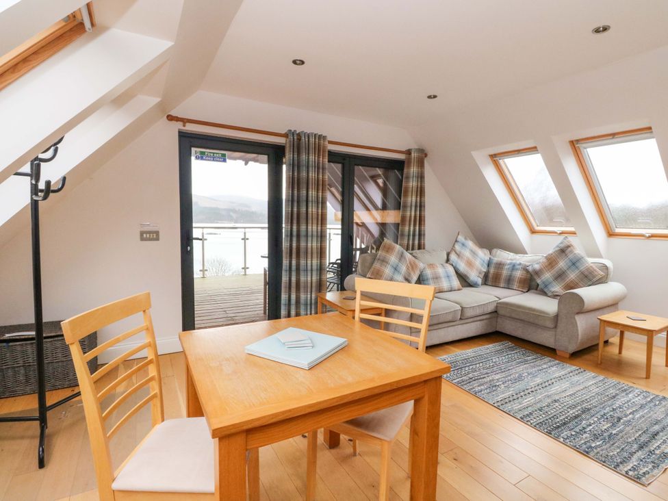 A living room with a sofa and dining table at The Apartment in Ardgour