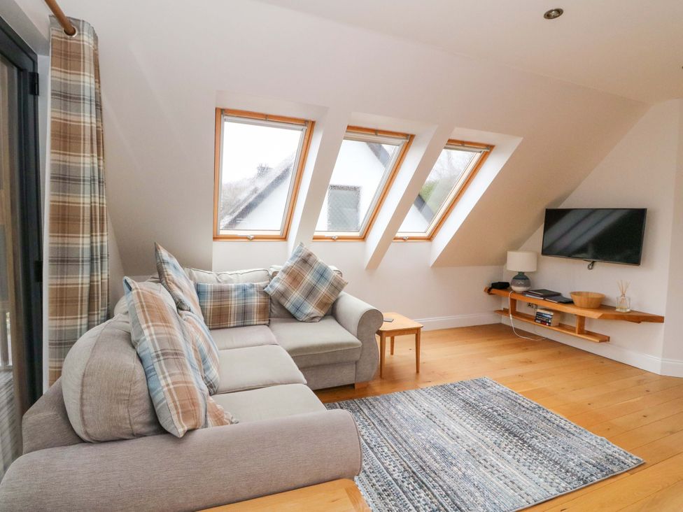 A living room with a couch, television, and a rug at The Apartment in Ardgour