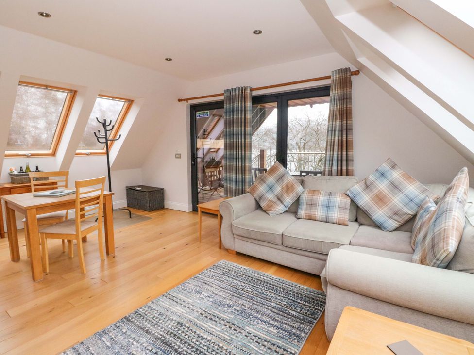 A living room with a sofa and dining area at The Apartment in Ardgour