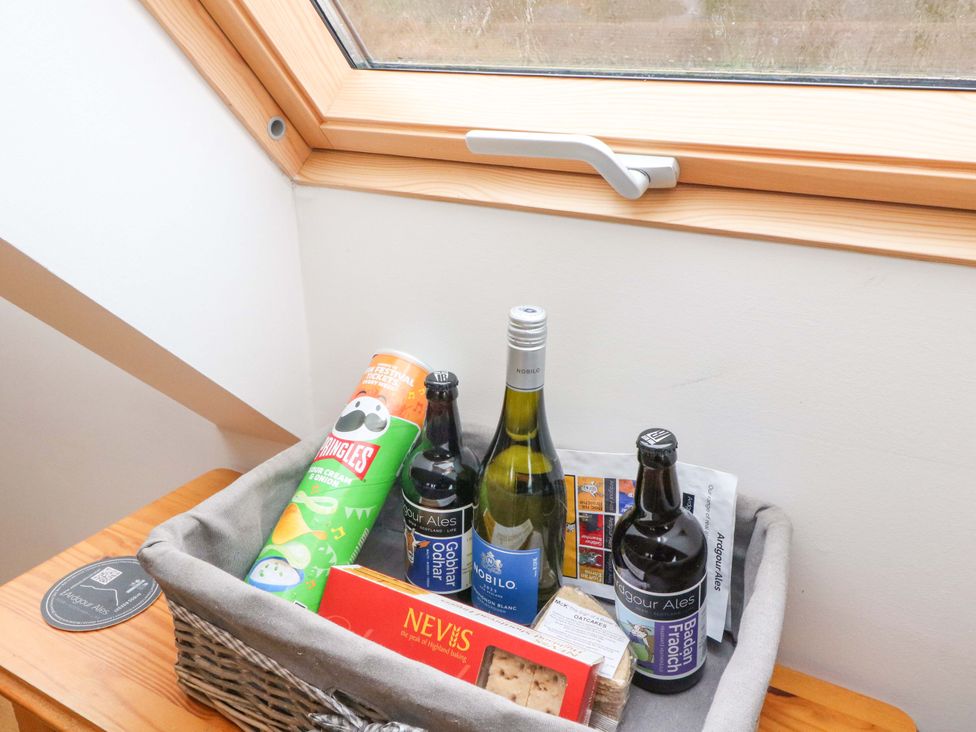 A basket with snacks and drinks on a table at The Apartment in Ardgour