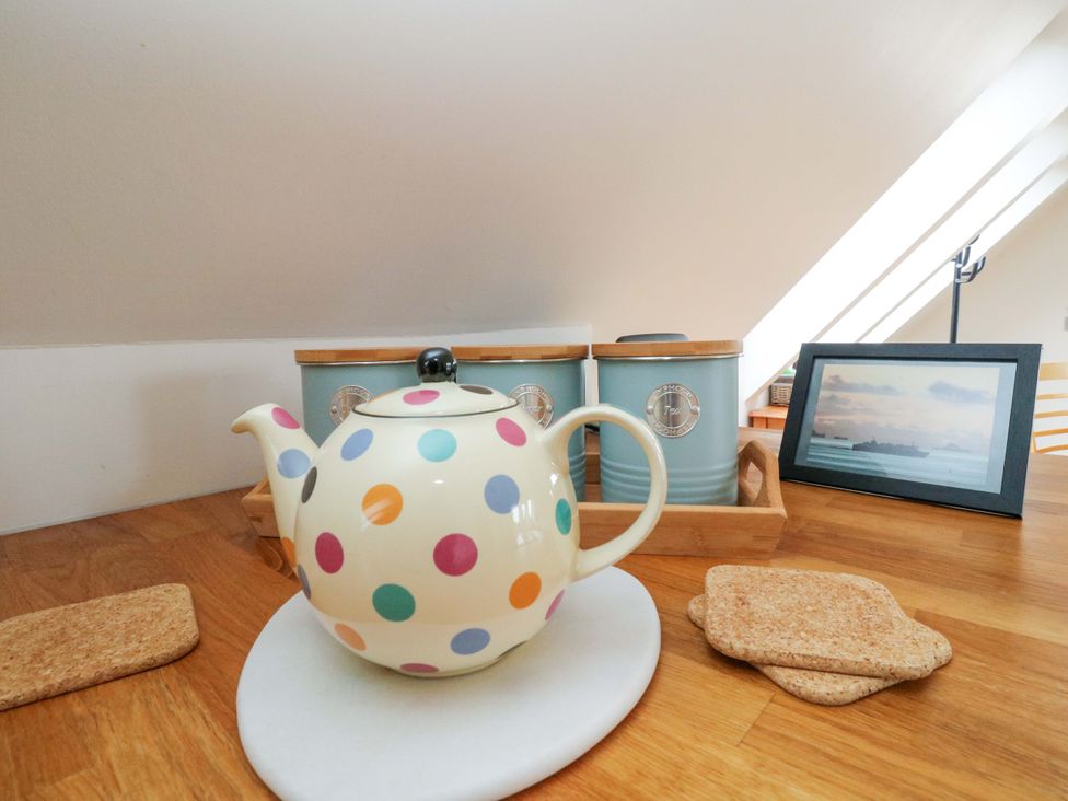 A teapot with coasters and storage containers in a kitchen at The Apartment in Ardgour
