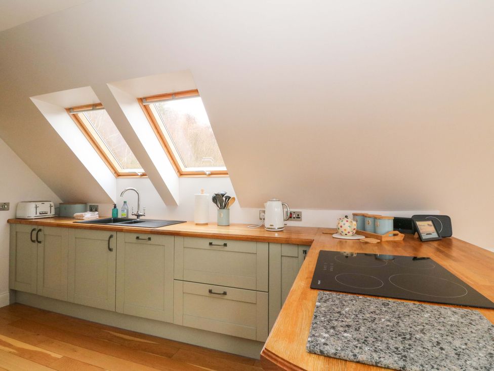 A kitchen with a sink and stove top at The Apartment in Ardgour