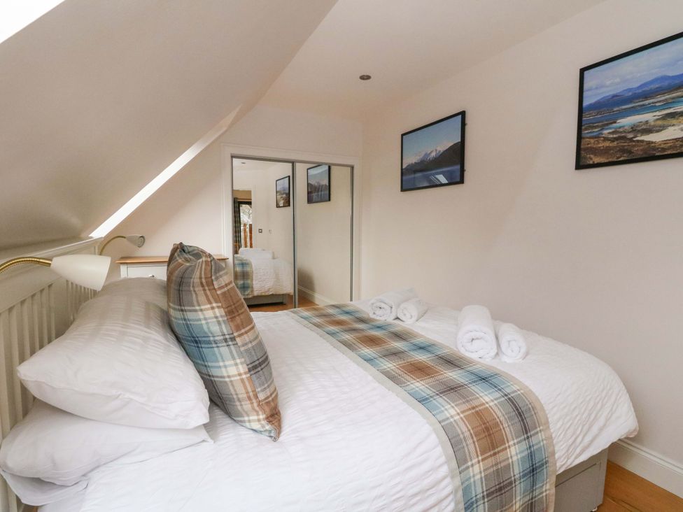 A bedroom with a bed and wall art at The Apartment in Ardgour