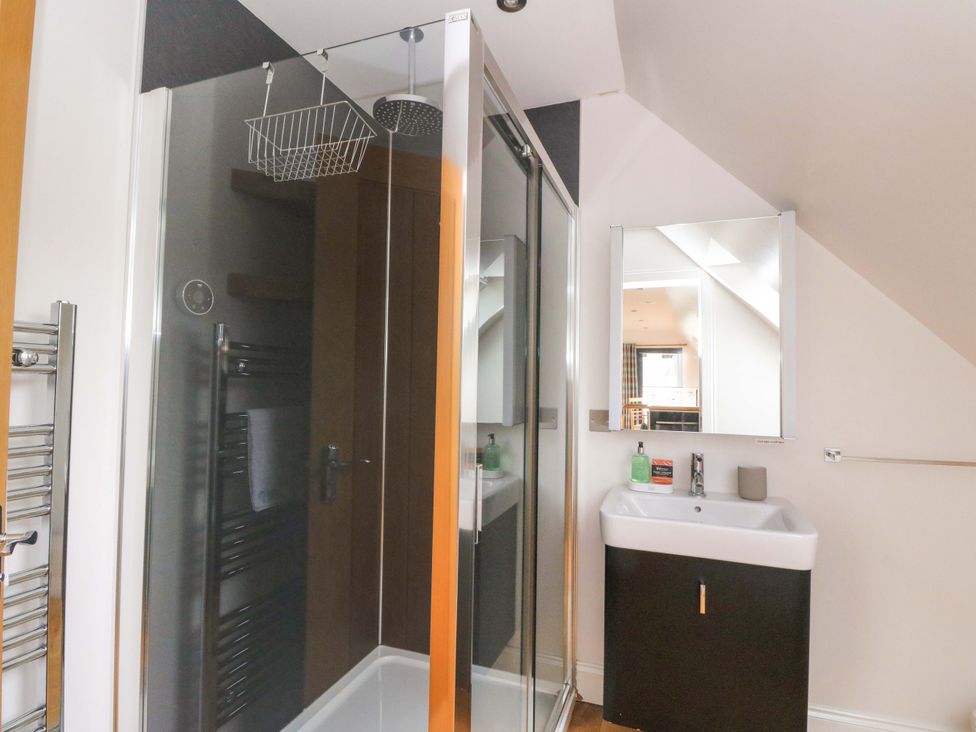 A bathroom with a shower, sink and storage at The Apartment in Ardgour