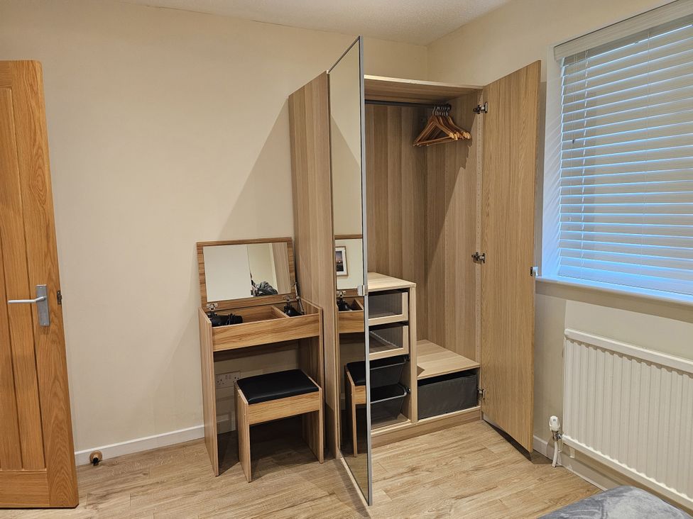 A wardrobe and vanity table in a bedroom at Seashells Cottage Lytham St. Annes