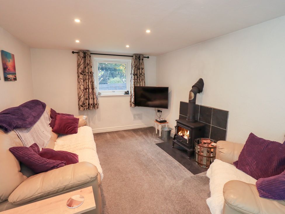 A living room with a fireplace and television at Kiln How in Threlkeld