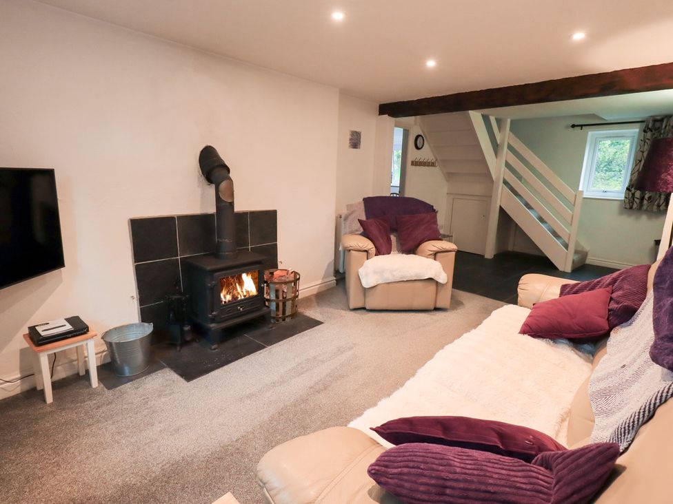 A living room with a fireplace and sofa at Kiln How Threlkeld