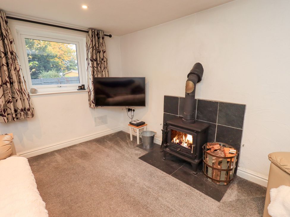 A living room with a fireplace and television at Kiln How Threlkeld