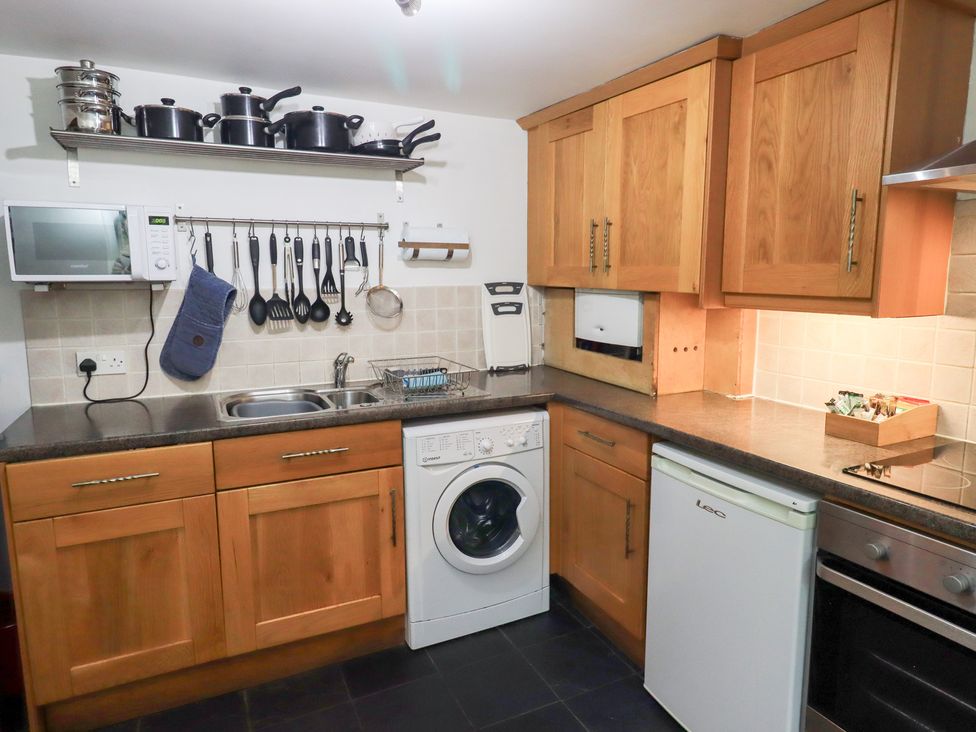 A kitchen with cabinets, sink, and appliances at Kiln How Threlkeld