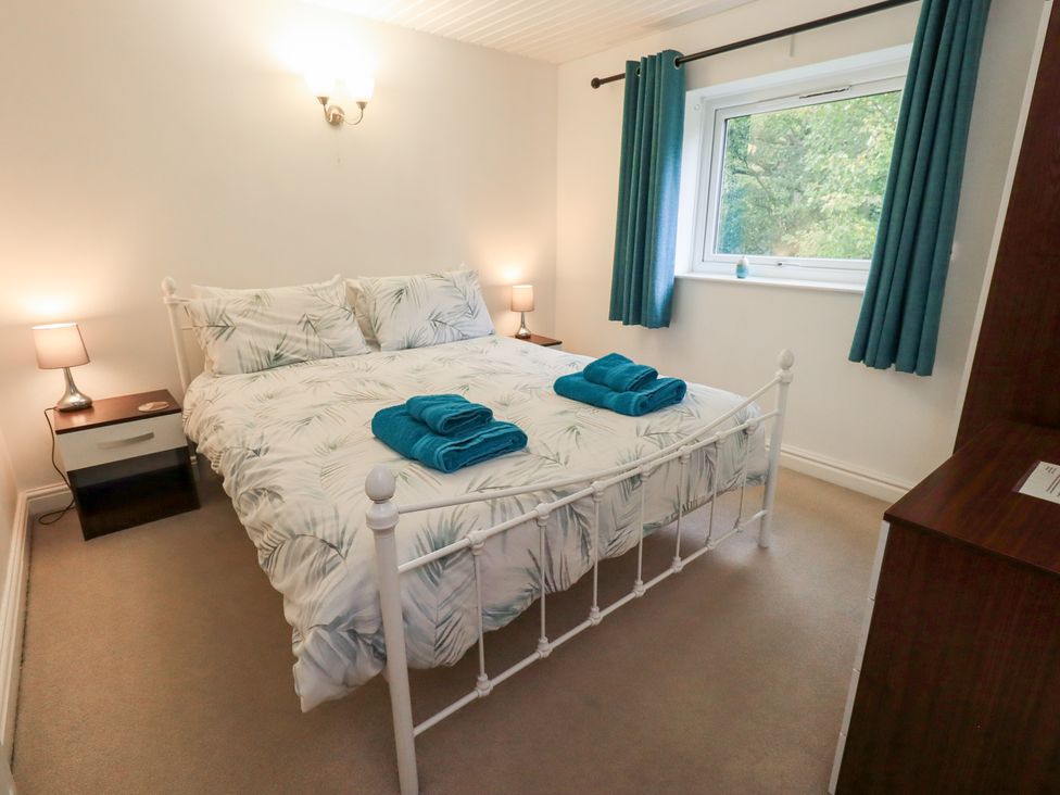 A bedroom with a double bed and lamps at Kiln How in Threlkeld