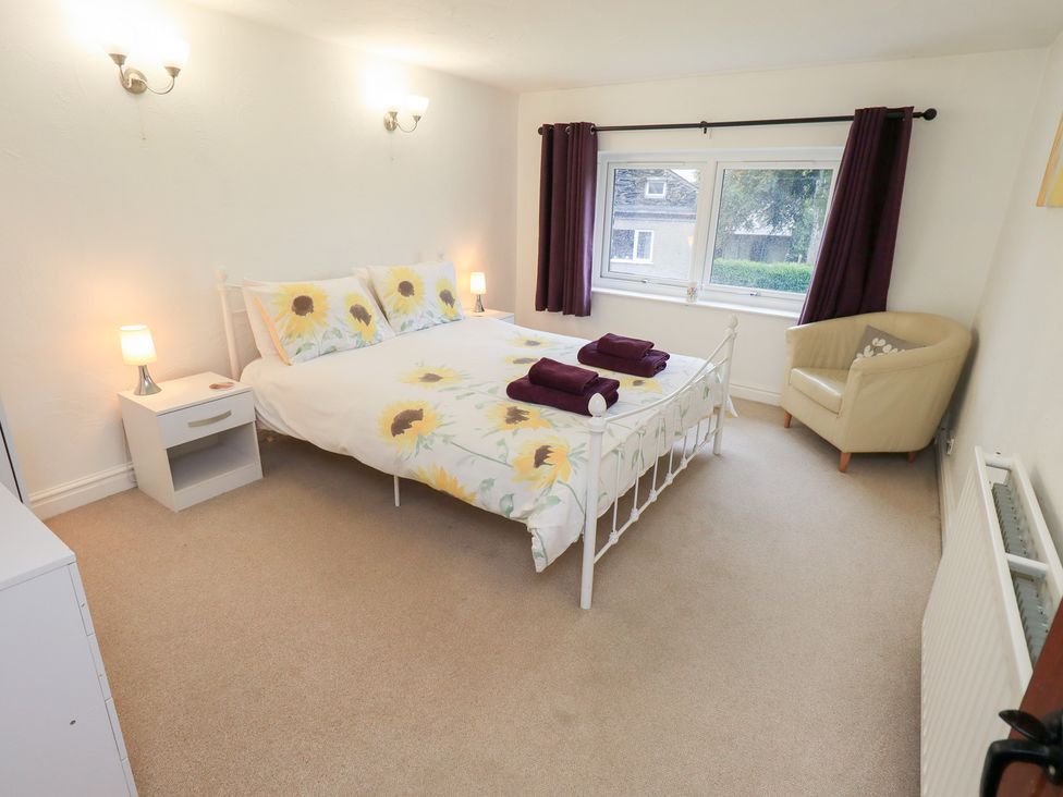 A bedroom with a bed and a chair at Kiln How in Threlkeld