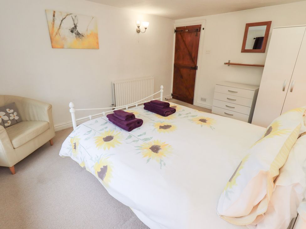 A bedroom with a bed and chair at Kiln How in Threlkeld