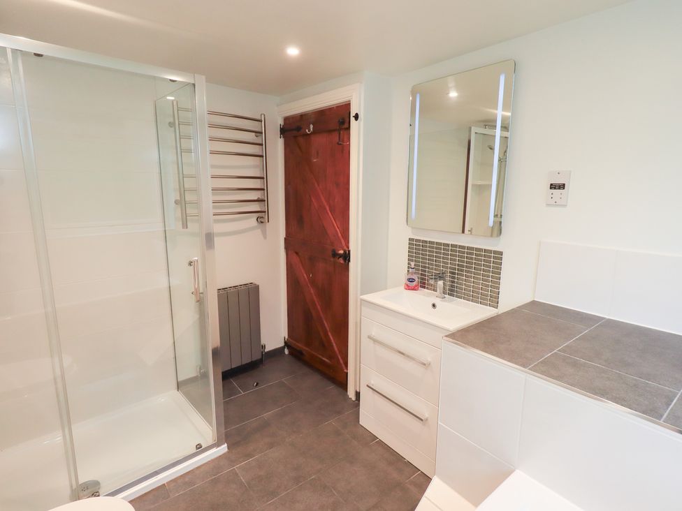 A bathroom with a shower and a vanity at Kiln How in Threlkeld