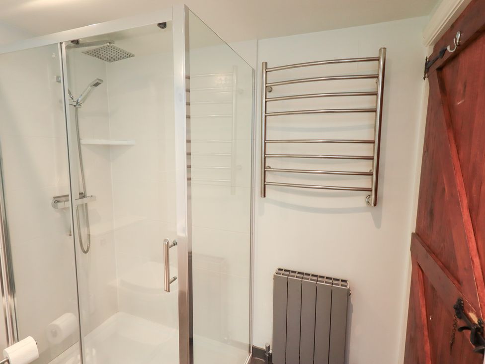 A bathroom with a shower and towel rail at Kiln How Threlkeld