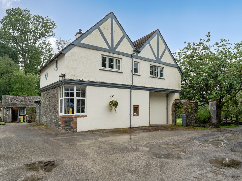 An exterior view of a house with stone walls and windows at Home Farmhouse at the Graythwaite Estate near Hawkshead