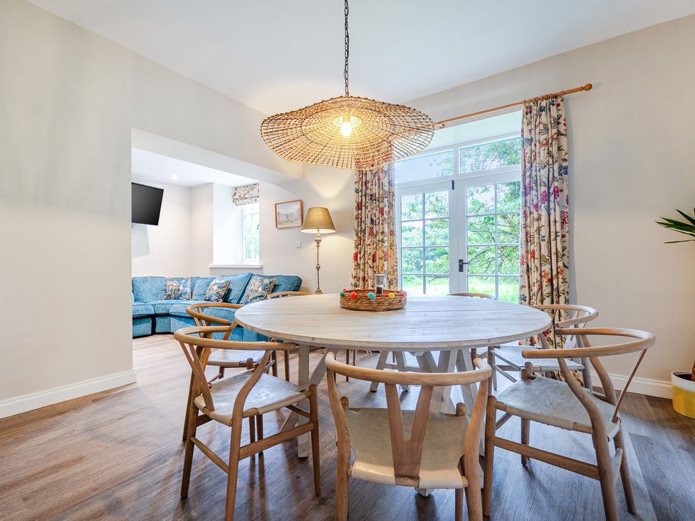 A dining room with a round table and chairs at Home Farmhouse at the Graythwaite Estate near Hawkshead