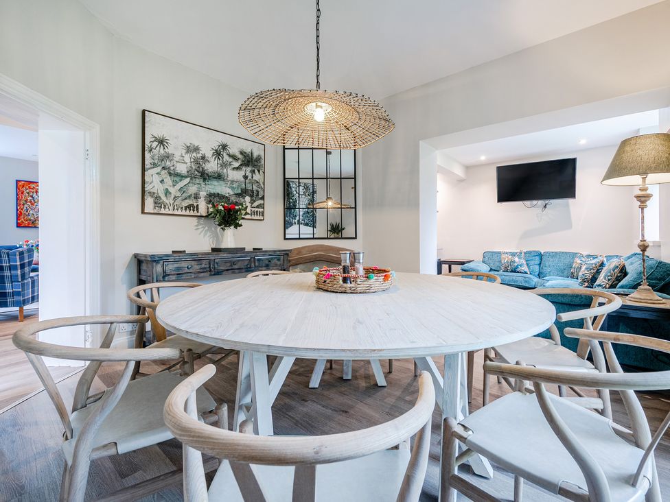 A dining room with a round table and chairs at Home Farmhouse at the Graythwaite Estate near Hawkshead
