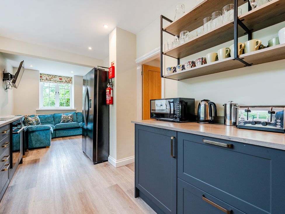 A kitchen with appliances and a living area at Home Farmhouse at the Graythwaite Estate near Hawkshead