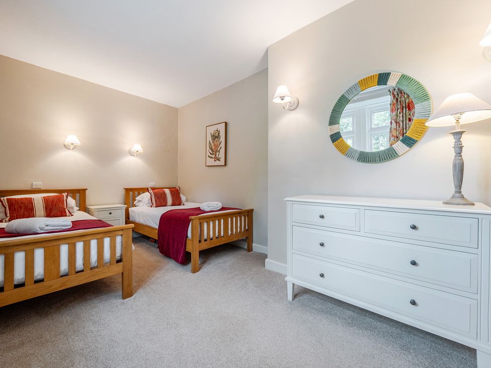 A bedroom with two beds and a dresser at Home Farmhouse at the Graythwaite Estate near Hawkshead
