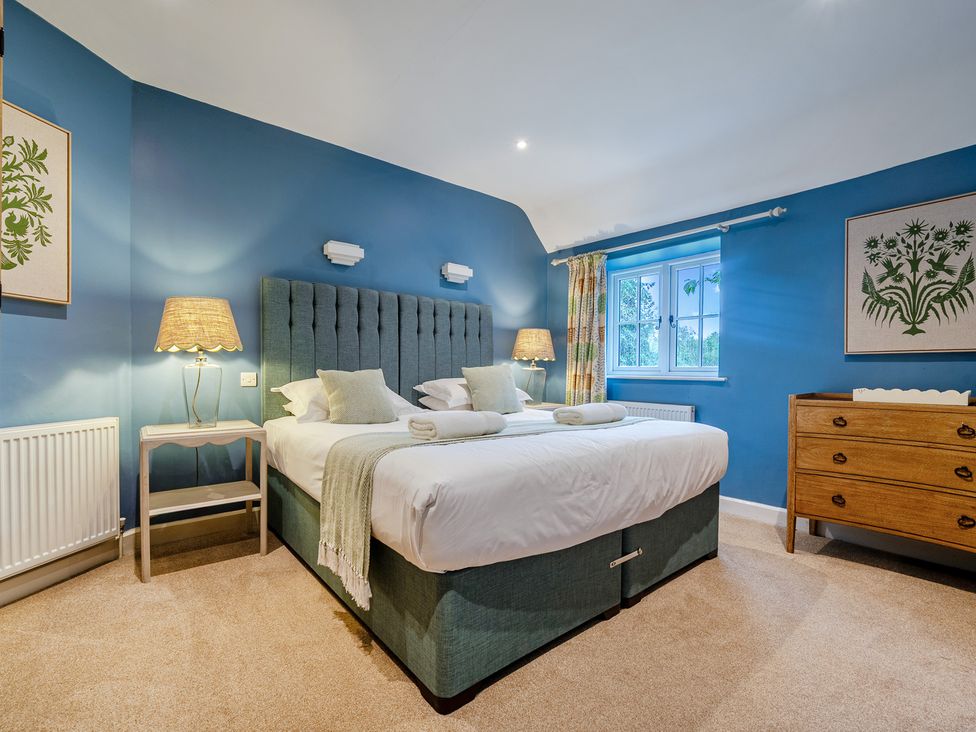 A bedroom with a bed and a dresser at Home Farmhouse at the Graythwaite Estate near Hawkshead