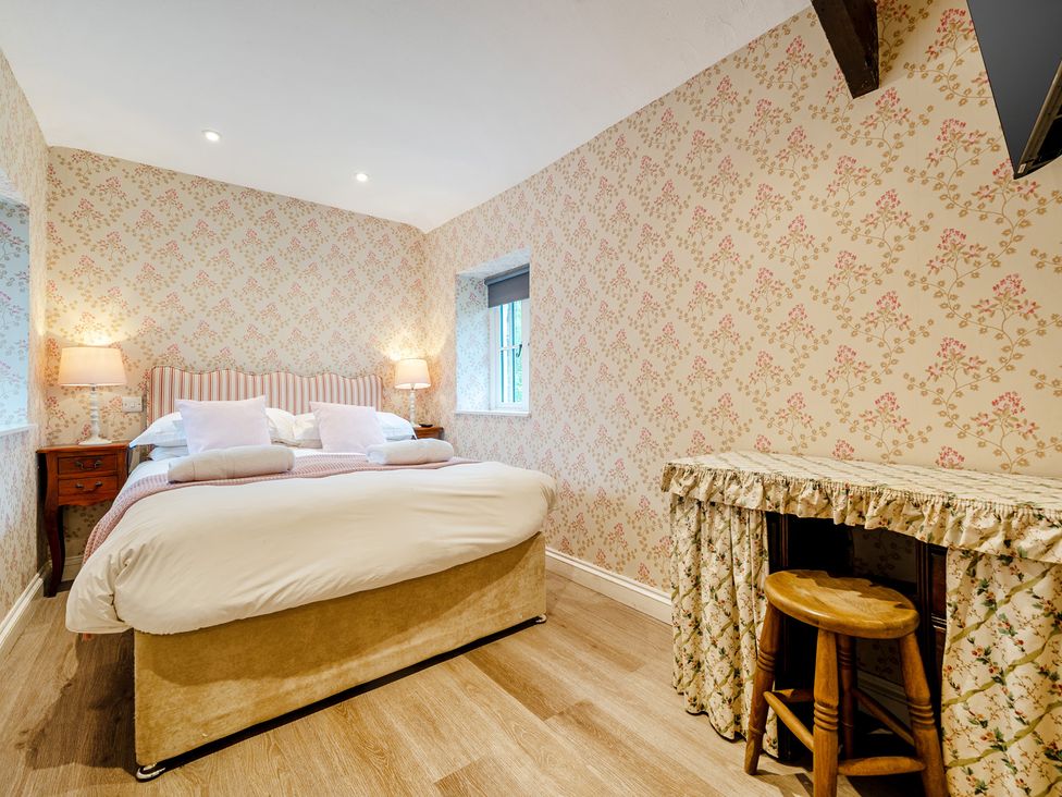 A bedroom with a bed and a nightstand at Home Farmhouse at the Graythwaite Estate near Hawkshead