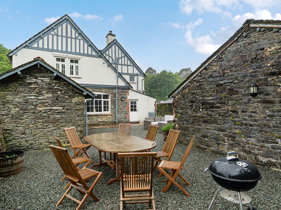 An outdoor dining area with a table and chairs at Home Farmhouse at the Graythwaite Estate near Hawkshead
