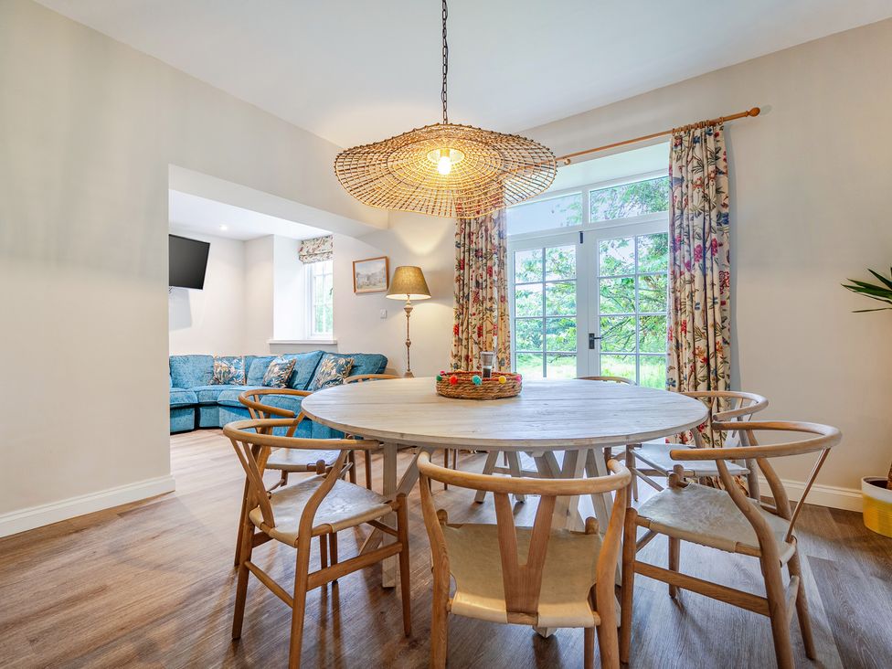 A dining area with a round table and chairs at Home Farmhouse at the Graythwaite Estate near Hawkshead