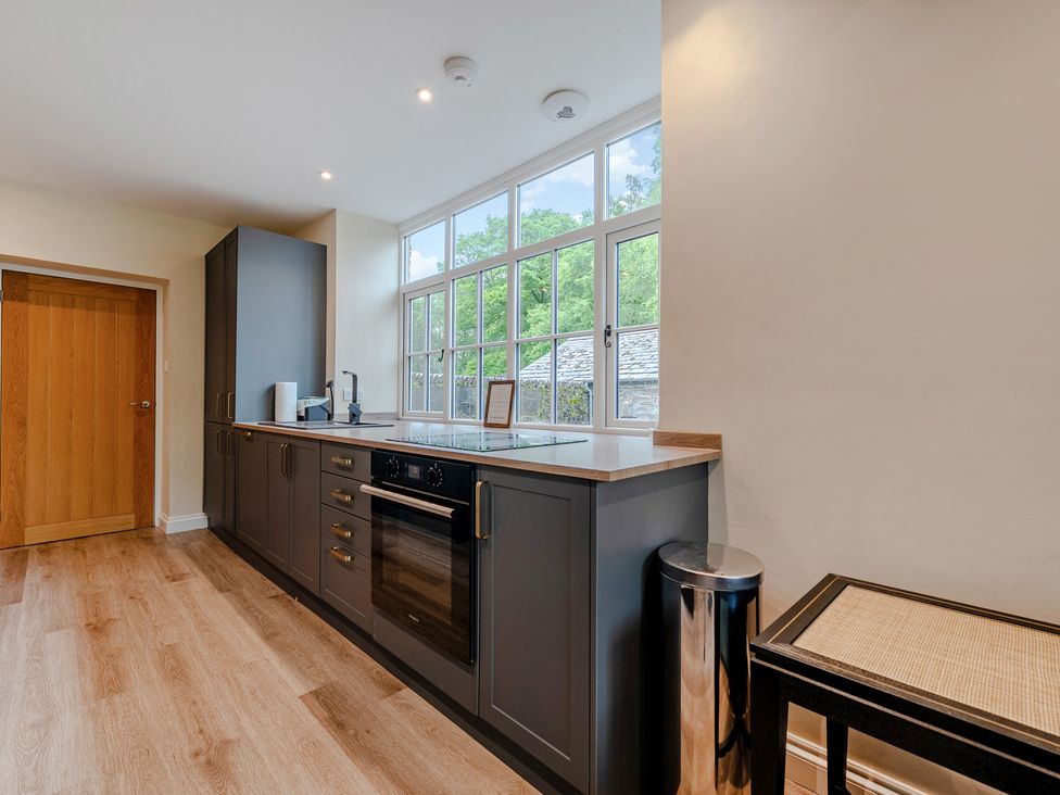 A kitchen with an oven and sink at Home Farmhouse at the Graythwaite Estate near Hawkshead