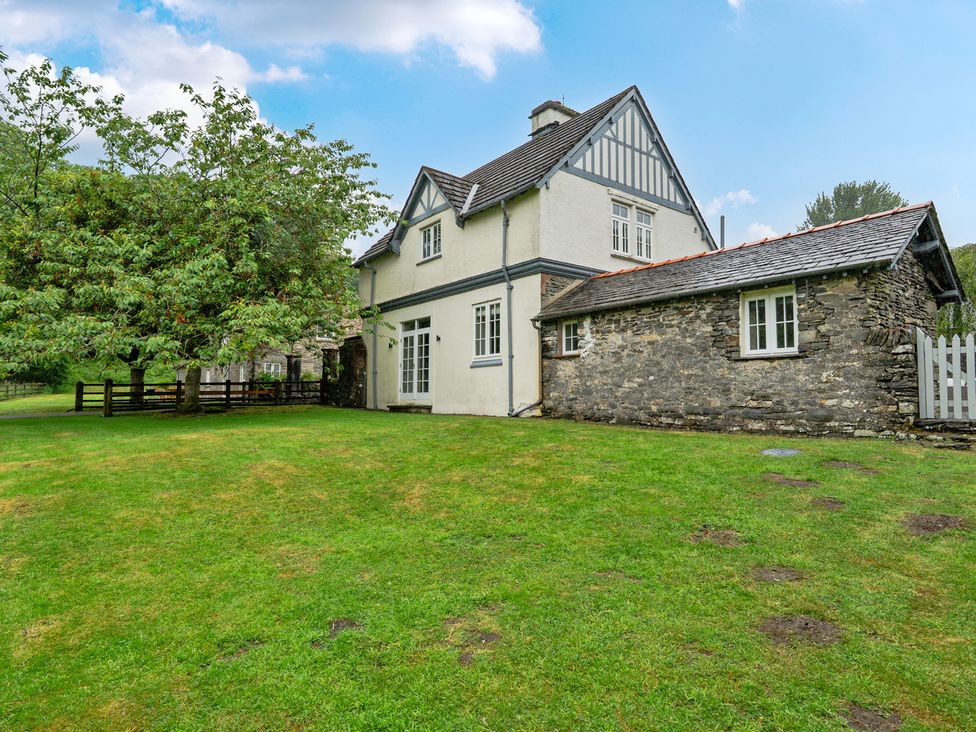 A house with a grassy area and trees at Home Farmhouse at the Graythwaite Estate near Hawkshead