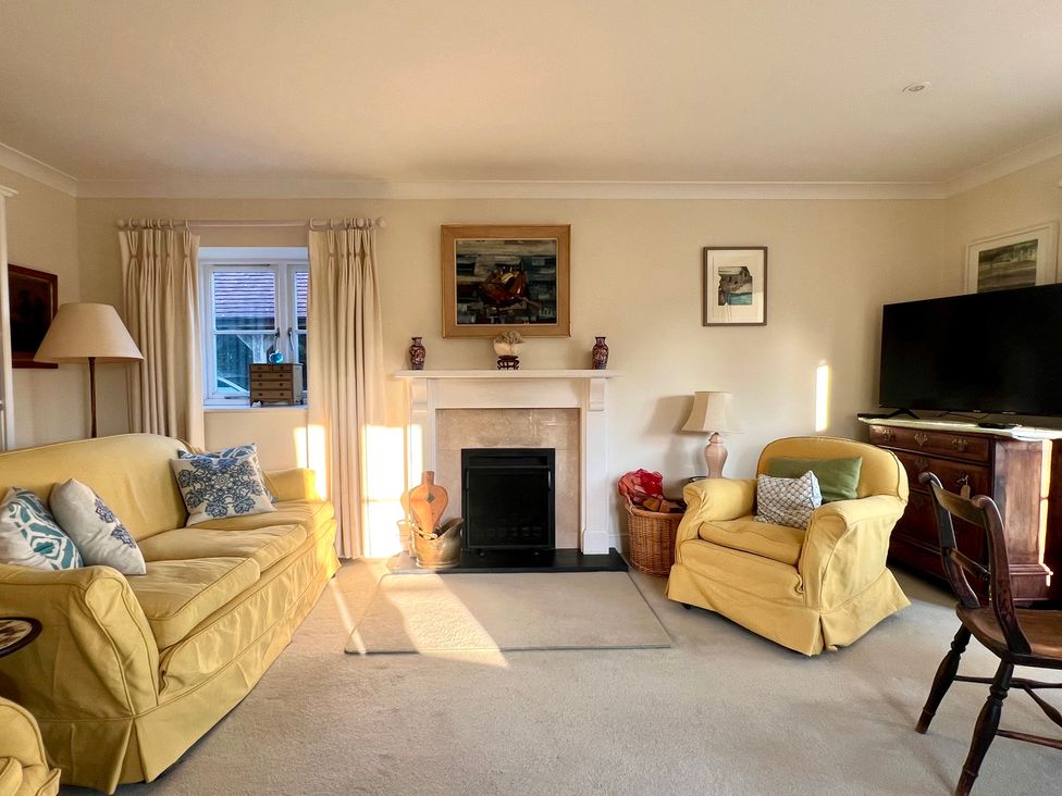 A living room with a fireplace and furnishings at Samstone in Donhead St. Mary near Ludwell