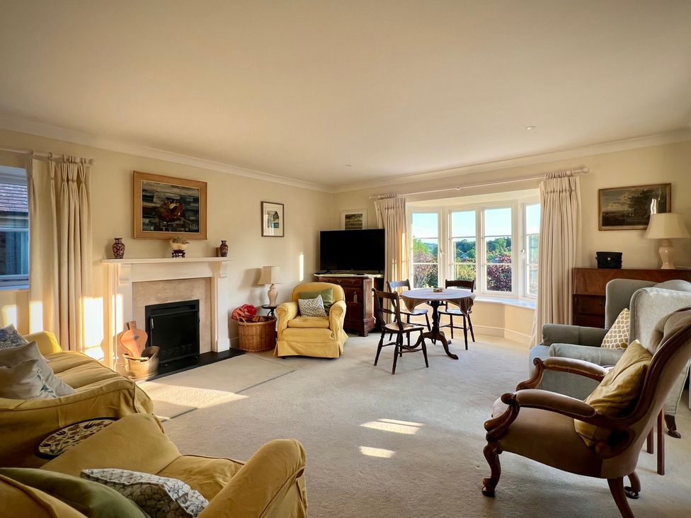 A living room with a table and furniture at Samstone in Donhead St. Mary near Ludwell