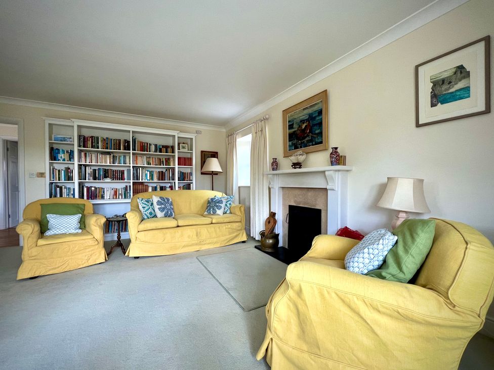 A living room with sofas and a bookshelf at Samstone, Donhead St. Mary near Ludwell