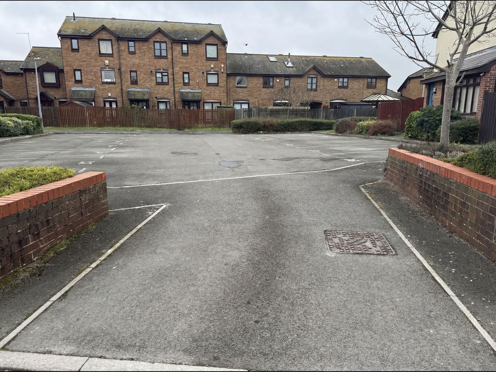 A parking lot with houses behind at Harbour View Poole